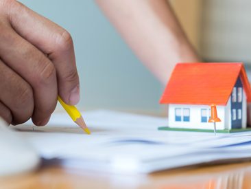 Home Design,Close-up architects are designing the house,model house place on house plan on the desk.